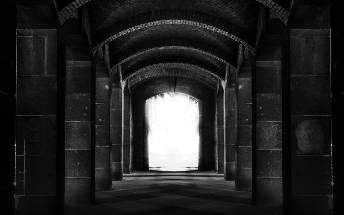 A dark arched passage opening onto light